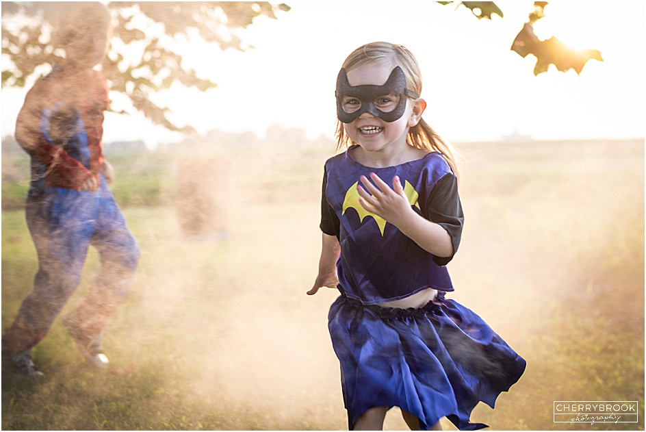Smiling children wearing super hero costumes. 